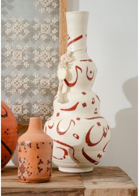 جرة فخارية منحنية مزينة بالخط العربي والشرابة